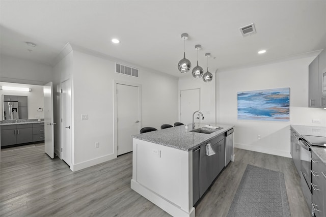 kitchen with gray cabinets, appliances with stainless steel finishes, sink, and a center island with sink