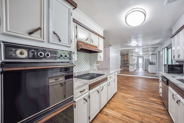 kitchen featuring black appliances, light hardwood / wood-style flooring, light stone counters, and white cabinets