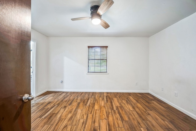 empty room featuring dark wood-type flooring and ceiling fan