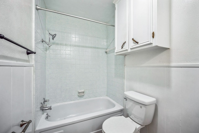 bathroom featuring toilet and tiled shower / bath combo