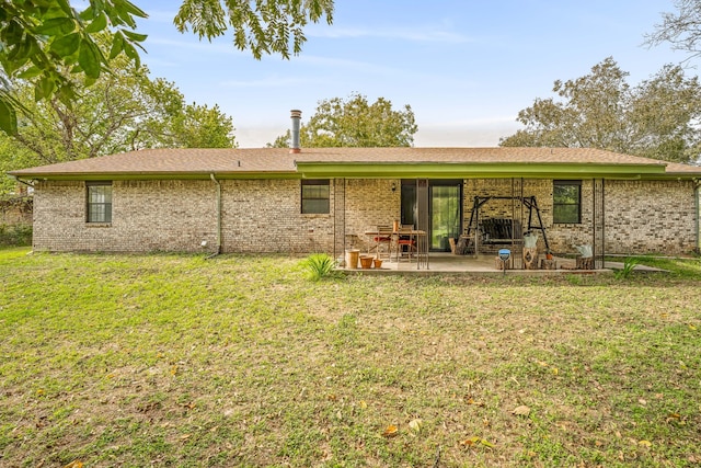 back of house with a patio and a lawn