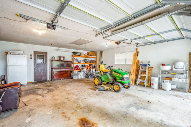 garage with a garage door opener and white refrigerator