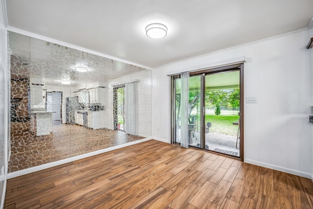 empty room featuring ornamental molding and wood-type flooring