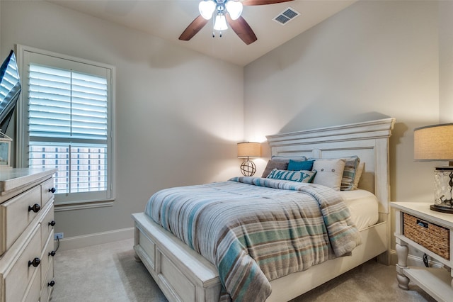 carpeted bedroom featuring multiple windows and ceiling fan