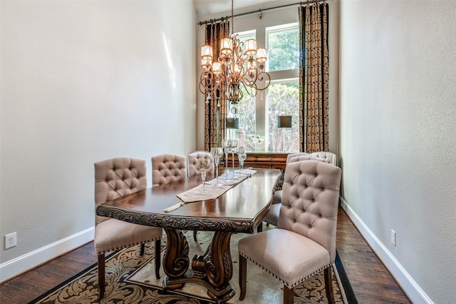 dining area with hardwood / wood-style floors and a notable chandelier