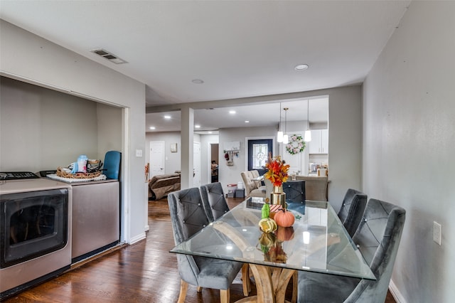 dining area with washing machine and dryer and dark hardwood / wood-style flooring