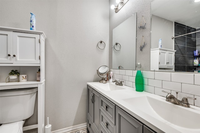 bathroom featuring vanity, decorative backsplash, a tile shower, and toilet