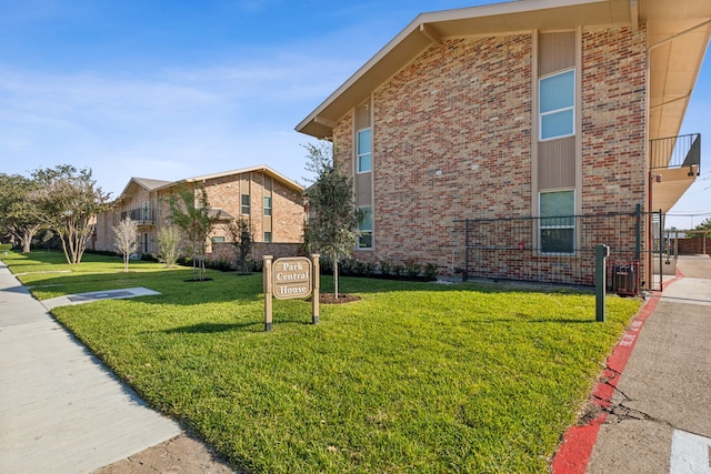 view of property exterior featuring cooling unit, a yard, and a balcony