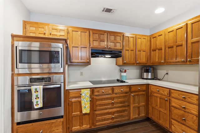 kitchen with appliances with stainless steel finishes and dark hardwood / wood-style flooring