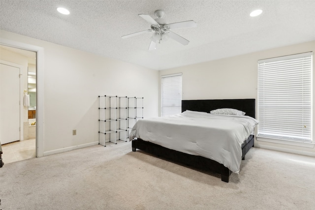 carpeted bedroom featuring ensuite bathroom, a textured ceiling, and ceiling fan