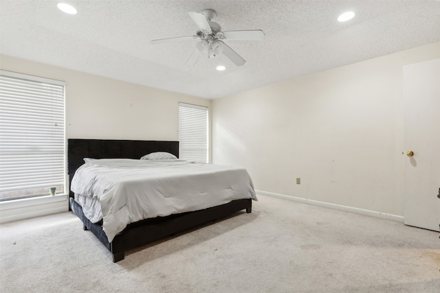 carpeted bedroom with a textured ceiling and ceiling fan