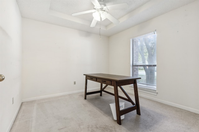 office space featuring ceiling fan, a raised ceiling, a textured ceiling, and light carpet