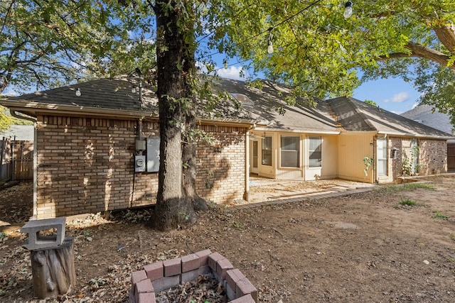 back of property featuring a patio and a fire pit