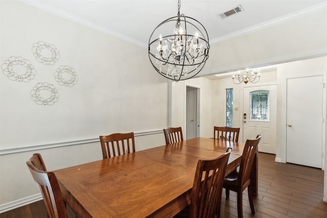 dining room with ornamental molding, an inviting chandelier, and dark hardwood / wood-style floors