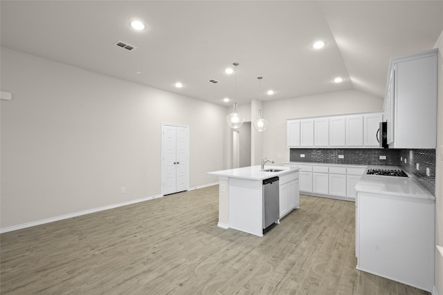 kitchen with appliances with stainless steel finishes, sink, white cabinets, hanging light fixtures, and a kitchen island with sink