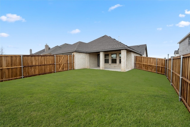 back of property with a yard and a patio