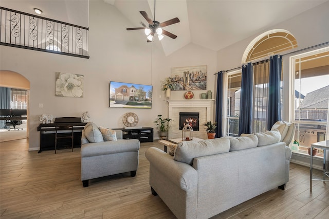 living room featuring a wealth of natural light, high vaulted ceiling, and light wood-type flooring