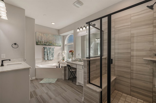 bathroom featuring vanity and independent shower and bath