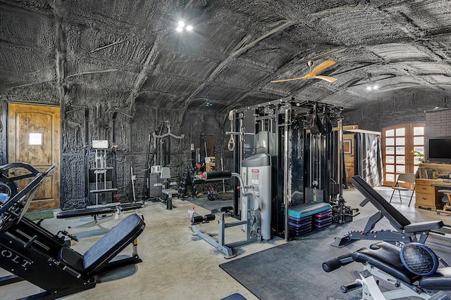 gym featuring lofted ceiling and water heater