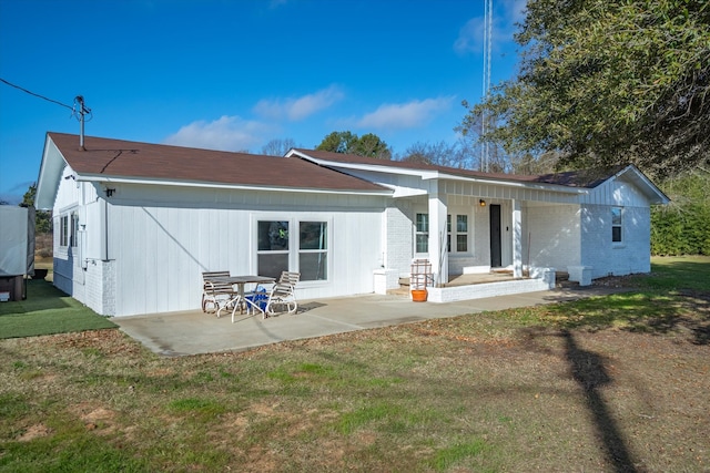 back of property with a patio and a lawn