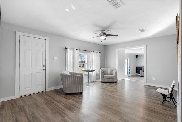 living room with ceiling fan and dark hardwood / wood-style flooring