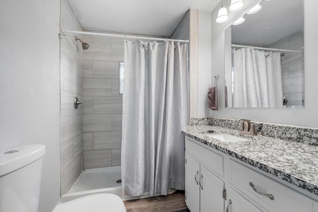 bathroom with vanity, a shower with shower curtain, hardwood / wood-style flooring, and toilet