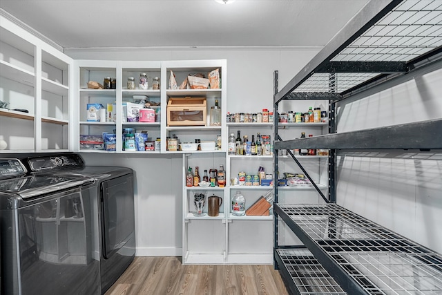 laundry room with ornamental molding, hardwood / wood-style flooring, and washer and clothes dryer