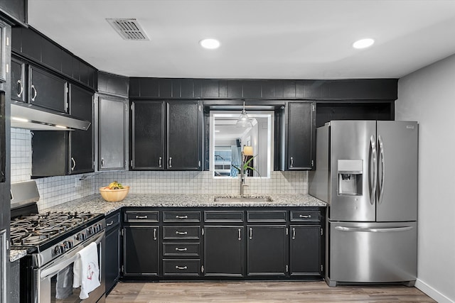 kitchen featuring light hardwood / wood-style flooring, tasteful backsplash, appliances with stainless steel finishes, and sink