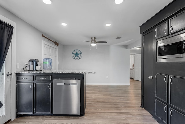 kitchen with kitchen peninsula, stainless steel microwave, light hardwood / wood-style floors, and ceiling fan