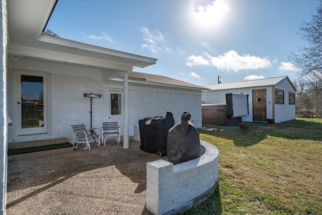 back of house featuring a yard, a hot tub, and a patio