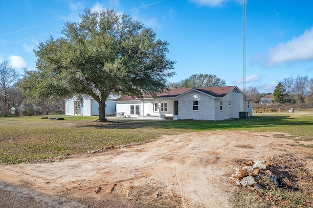 view of front of home with central AC and a front yard