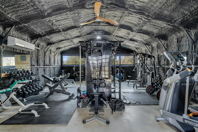 exercise room featuring an AC wall unit, vaulted ceiling, and a healthy amount of sunlight