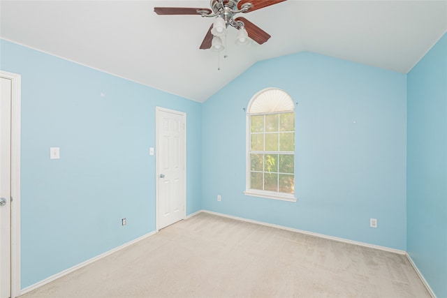 carpeted empty room with vaulted ceiling and ceiling fan