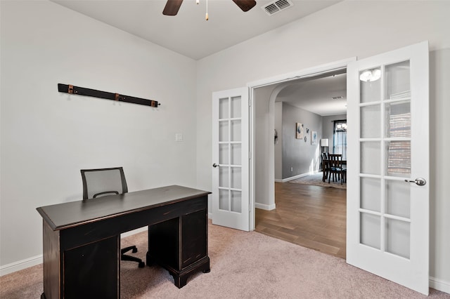 carpeted home office with ceiling fan and french doors