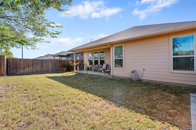 back of house featuring a lawn and a patio area