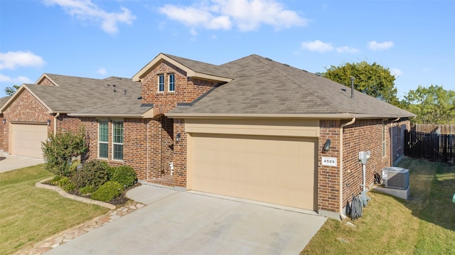 view of front of home featuring central AC, a garage, and a front lawn