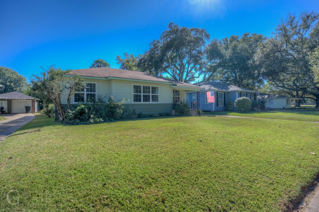 single story home with a front yard and a garage