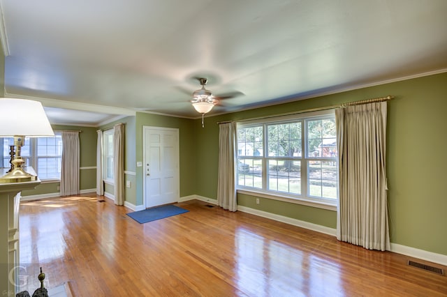 entryway with crown molding, light hardwood / wood-style floors, and ceiling fan