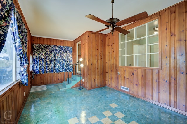 empty room with wood walls and ceiling fan