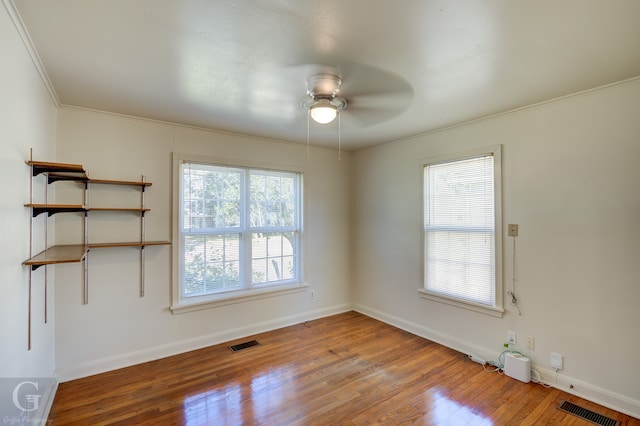 unfurnished room featuring crown molding, wood-type flooring, and ceiling fan