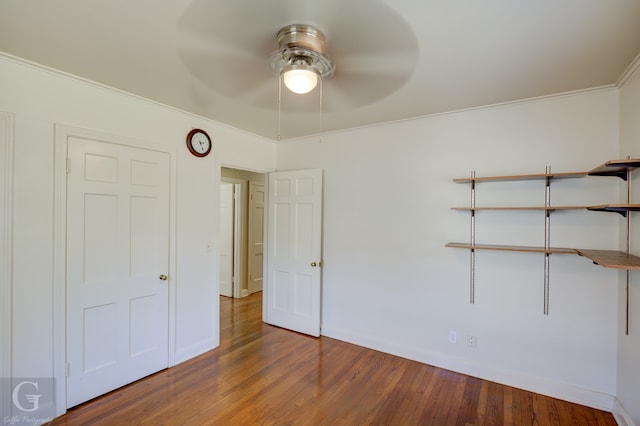 unfurnished bedroom with a closet, ceiling fan, crown molding, and wood-type flooring