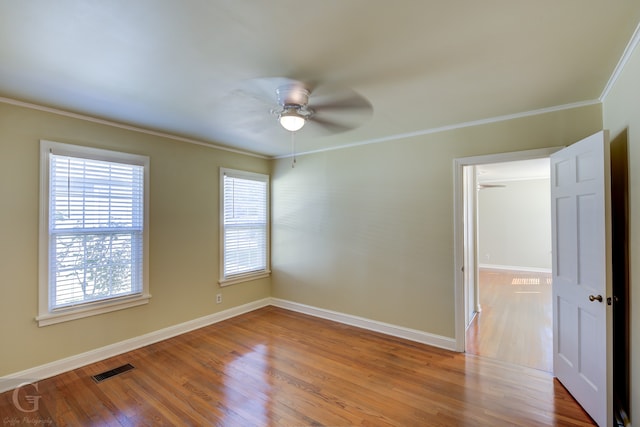 empty room with ceiling fan, crown molding, and light hardwood / wood-style flooring