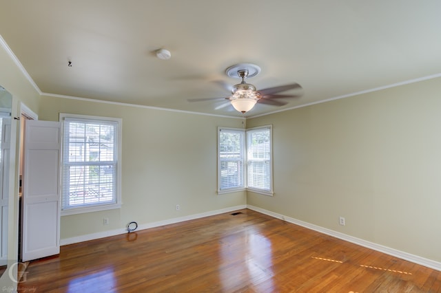 empty room featuring ceiling fan, crown molding, and hardwood / wood-style floors