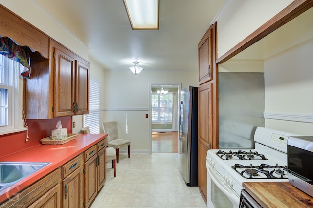 kitchen with appliances with stainless steel finishes, sink, and a chandelier