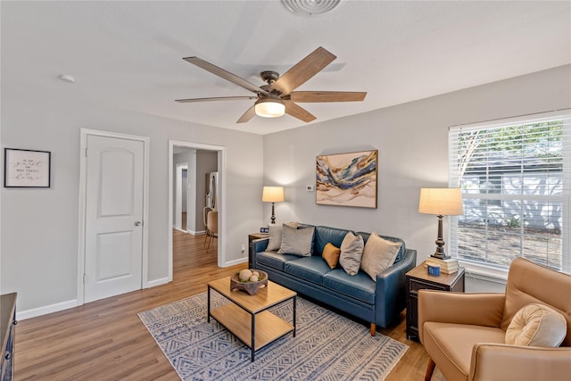 living room with ceiling fan and light hardwood / wood-style floors