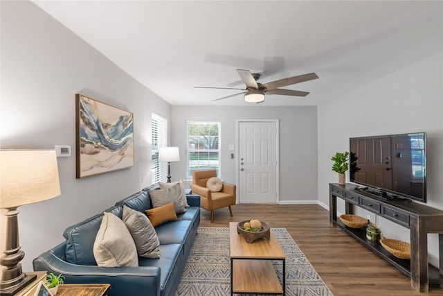 living room featuring ceiling fan and dark hardwood / wood-style floors