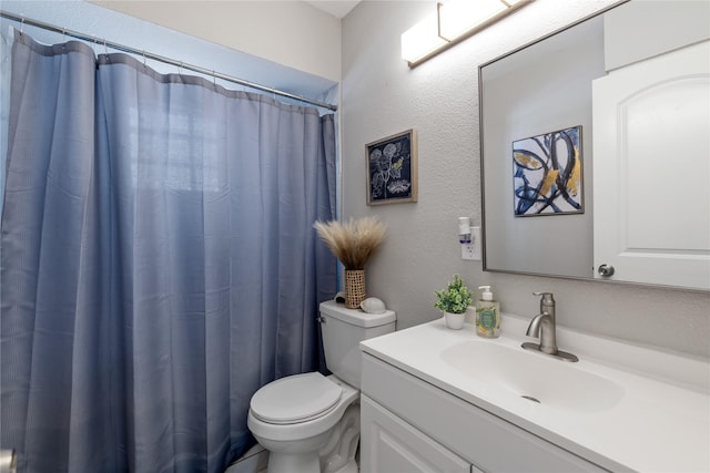 bathroom featuring walk in shower, vanity, and toilet