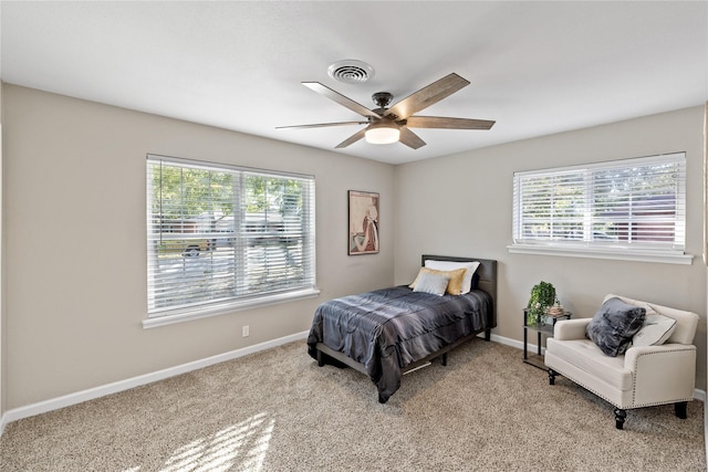 carpeted bedroom featuring ceiling fan and multiple windows