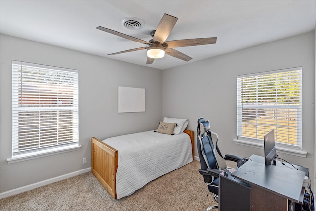 bedroom with ceiling fan, light carpet, and multiple windows