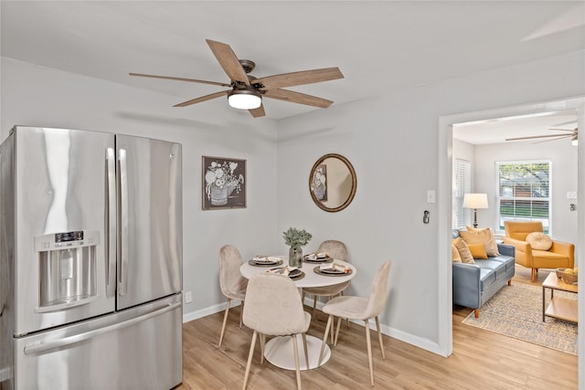 dining room with ceiling fan and light wood-type flooring